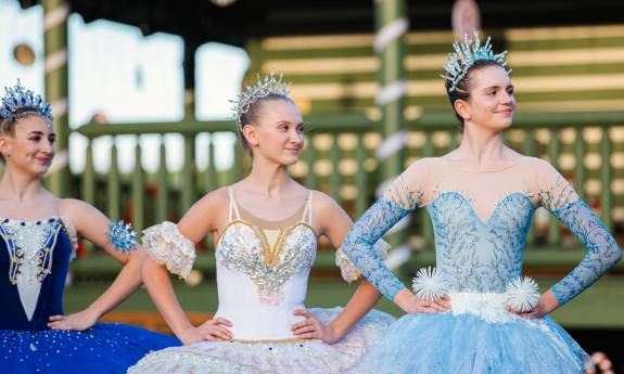 Three ballerinas, dressed as ice princesses, on the rink at Ancient City Farmstead