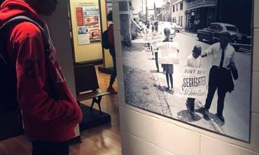 A visitor to the Lincolnville Museum and Cultural Center gazes at an image of Dr. King and a child at a segregation protest in St. Augustine.