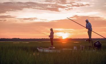 Two people fishing during sunset