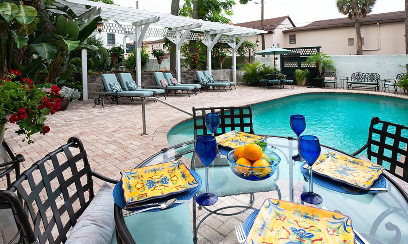 Poolside table setting in front of pegoda and lounge chairs at Kenwood Inn