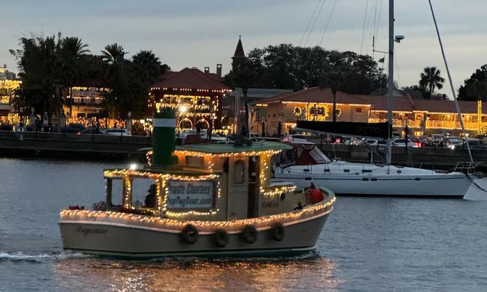 The tiny tug, a 26-foot six-passenger vessel, decorated for Nights of Lights