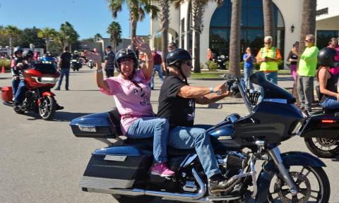 Riders on motorcycles, many wearing pink, take off on the Unity Ride to raise funds for breast cancer patients.